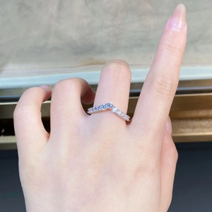 Gros plan d'une bague en V argentée sertie de zircons sur une main pour le mariage