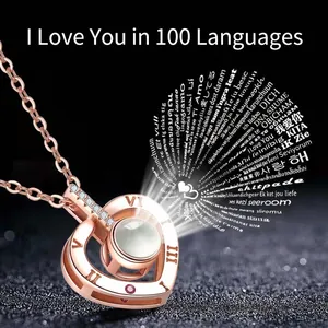 Rose gold heart projection necklace with Roman numerals showing 100 languages I Love You