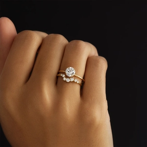 Close-up of sparkling moissanite bridal set on hand featuring a gold plated claw ring
