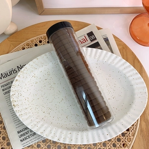 Close-up of high-elastic dark brown hair ties neatly packed in a clear storage tube
