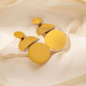 Irregular gold circular pendant earrings in titanium steel on elegant satin background