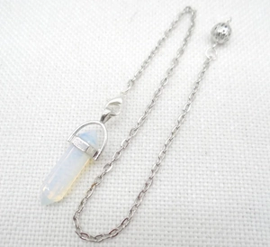 Detailed macro view of an opal hexagonal crystal pendant with a silver metal chain
