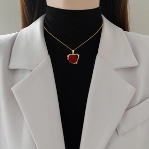 Luxurious gold titanium necklace with a flocked red rose pendant on a female model