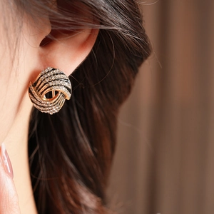 Gros plan détaillé d'une boucle d'oreille vintage avec strass et émail noir sur l'oreille
