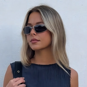 Chic silver rectangular metal sunglasses with dark lenses on a fashion model
