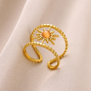 Macro detail of golden stainless steel double-layer star ring with orange gemstone