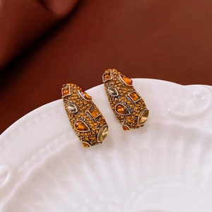 Détail macro de boucles d'oreilles vintage en forme de goutte avec cristaux ambrés sur porcelaine