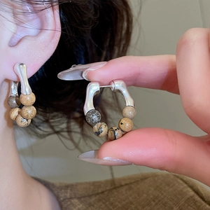 Détail de boucles d'oreilles vintage en argent avec perles de pierre naturelle sur modèle