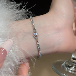 Macro detail of sparkling zircon evil eye bracelet with polished silver tennis chain