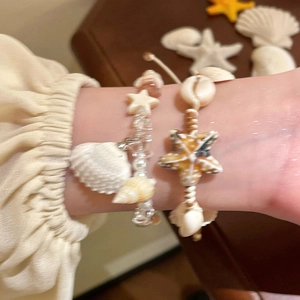 Bohemian style bracelet set with conch shells and starfish pendants on wrist