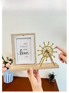 Close-up of the rotating golden Ferris wheel and 4x6 wooden photo frame on a desk