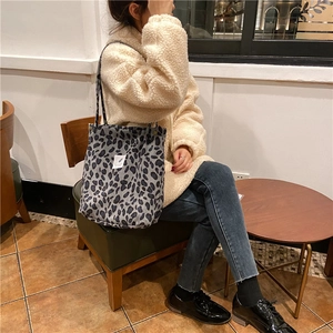 Detalle del bolso tote de pana con estampado de leopardo y pequeña etiqueta en un café