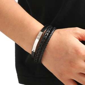 Close-up of multilayer black leather bracelet with silver metal bars on a male model wrist