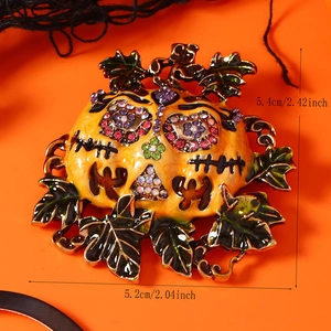 Detailed view of Halloween pumpkin brooch with colorful rhinestones on orange background