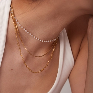 Collier triple rang en acier doré 18K avec perles délicates sur un mannequin femme