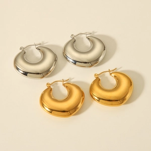 Detailed view of chunky hollow hoop earrings in polished gold and silver metallic finishes