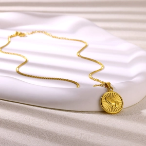 Detailed macro view of 18K gold tarot pendant featuring embossed praying hands design
