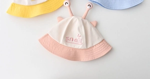 Detail of snail-themed baby sun hats with 3D antennae and delicate 'snail' embroidery
