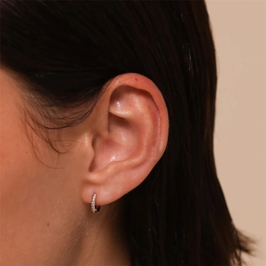 Close-up of gold S925 silver hoop earring with paved zircon stones on model ear