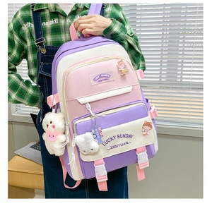 Detailed back view of a purple and pink nylon school backpack with plush pendant