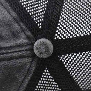 Macro shot of cotton twill panels and breathable mesh with a top button on trucker hat