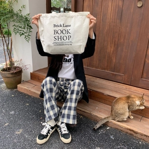 Lifestyle shot of large canvas tote bag with black book shop print on off-white fabric