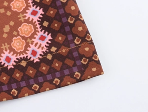 Close-up of woven fabric texture with orange floral and purple geometric print details