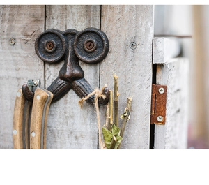 Detail van vintage gietijzeren wandhaak in snorontwerp op een houten achtergrond