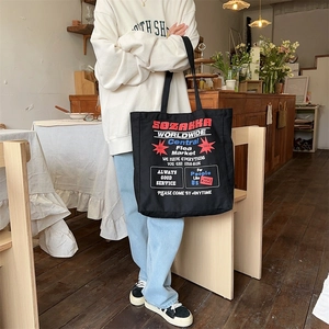 Detail of black canvas tote bag with vintage typography and large capacity design