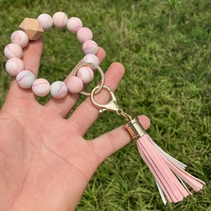 Close-up of pink marble silicone beads and wood bead keychain with leather tassel