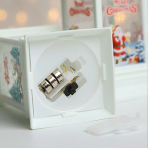 Close-up of white Christmas lantern base showing battery compartment and power switch