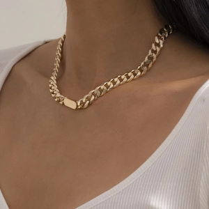 Detailed view of chunky gold curb chain necklace with a smooth rectangular metal plaque