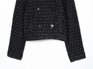 Close-up of black tweed texture with silver metallic threads and double-breasted buttons