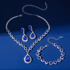 Macro detail of silver necklace set featuring teardrop blue gems and clear rhinestones