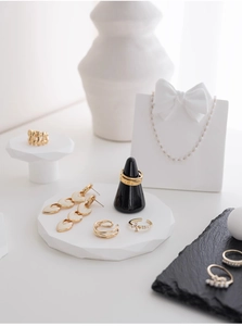 Detaillierte Anordnung von Goldschmuck-Sets auf geometrischen Ständern mit Halskette