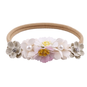 Detailed view of elastic baby headband with five handmade fabric flowers and pearls