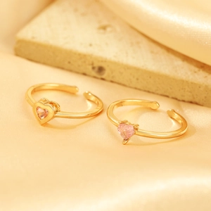 Detail of two adjustable gold-plated rings featuring pink heart-shaped zircon stones