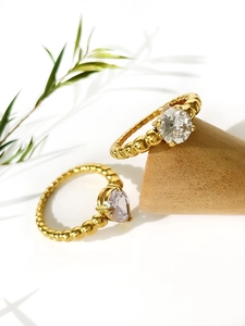 Detailed macro of gold plated stackable rings with round and pear cut sparkling zircons