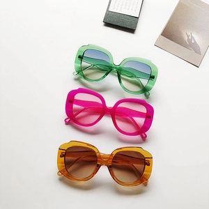 Vertical arrangement of oversized sunglasses in green, pink and orange with gradient lenses