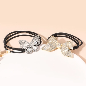 Close-up of sparkling rhinestone butterfly and bow hair ties on a white display stand