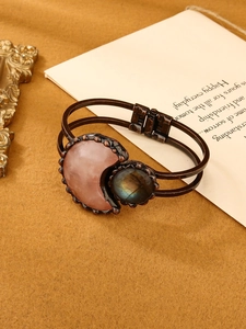 Detail view of vintage bronze cuff with pink crescent stone and blue labradorite inlay
