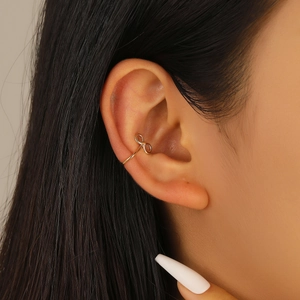 Gros plan sur un protège-oreille doré en forme d'infini pour un look minimaliste