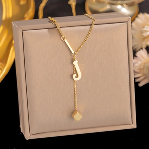 Detail view of gold titanium letter J pendant necklace with asymmetric chain design