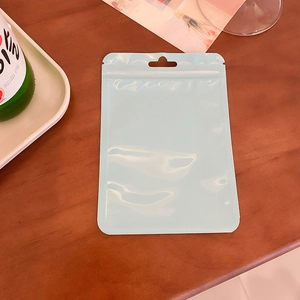 Detail of light blue resealable plastic bag with hanging hole on wood table