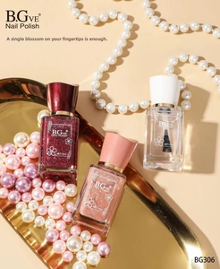 Three 14ml nail polish bottles in red and pink glitter on a tray with pearls