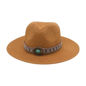 Détail d'un chapeau de paille à large bord avec perle turquoise et ruban géométrique