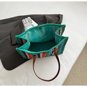 Top view of striped woven tote bag showing blue lining, magnetic closure, and inner pocket