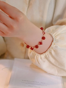 Detailed view of red agate four-leaf clover bracelet with gold-beaded edges and beads