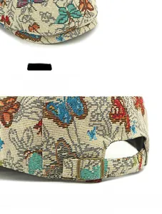Detail of the vintage jacquard beret with butterfly pattern and brass adjustment buckle