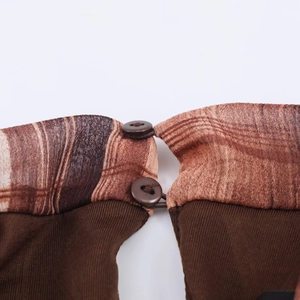 Close-up of checkered dress neckline featuring dual brown wooden buttons and elastic loops